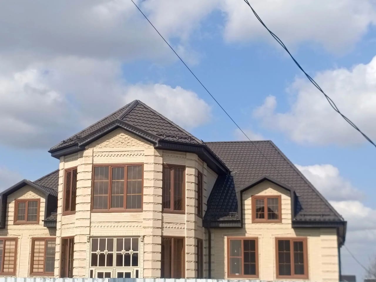 Многоскатная крыша частного дома с водостоками